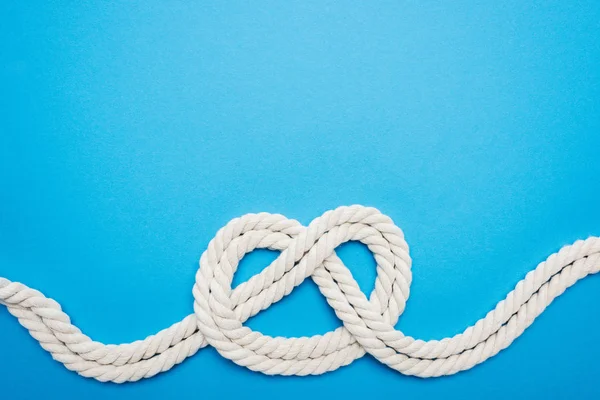 White ropes with sailor knot isolated on blue — Stock Photo