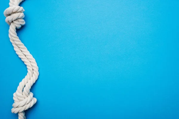 White, twisted, nautical ropes with sea knot isolated on blue — Stock Photo