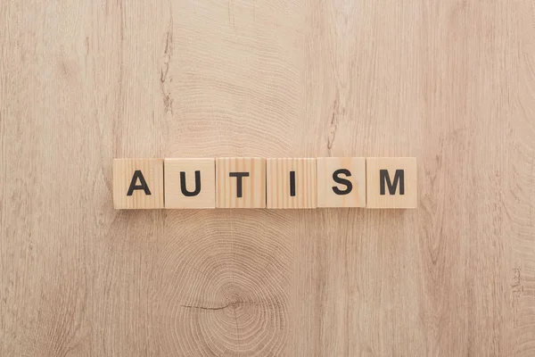 Vue du dessus du lettrage autisme en cubes de bois sur table en bois — Photo de stock