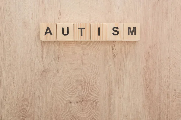 Vue du dessus du lettrage autisme fait de cubes sur une table en bois — Photo de stock