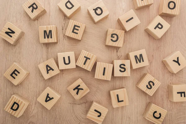 Top view of autism lettering made of wooden cubes with different letters on table — Stock Photo