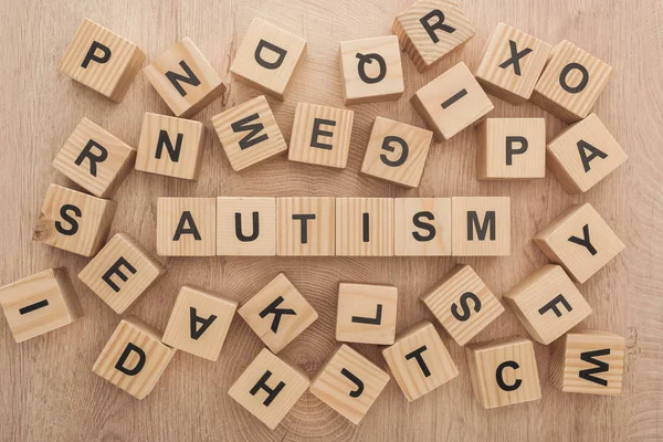 Top view of autism lettering made of wooden blocks among another letters — Stock Photo