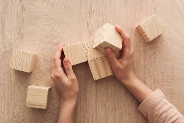 Cropped view of female hands near blank wooden cubes — Stock Photo