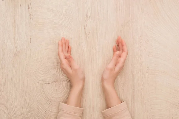 Vista recortada de las manos femeninas en la mesa de madera con espacio para copiar - foto de stock