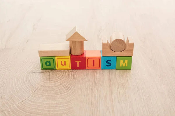 Autismus-Schriftzug aus bunten Würfeln mit Bausteinen auf Holzoberfläche — Stockfoto