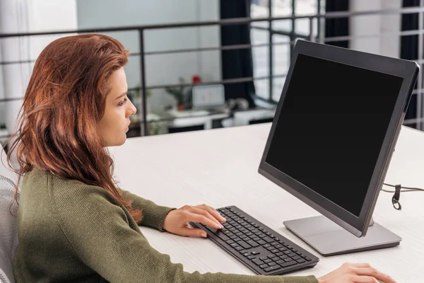Впевнена жінка використовує комп'ютер на робочому місці в офісі — стокове фото