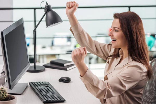 Heureuse jeune femme se réjouissant sur le lieu de travail dans un bureau moderne — Photo de stock