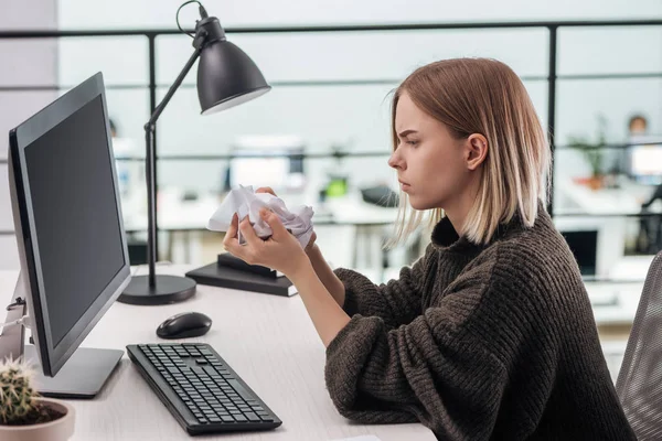 Trauriges Mädchen sitzt mit zerknittertem Papier am Arbeitsplatz im modernen Büro — Stockfoto