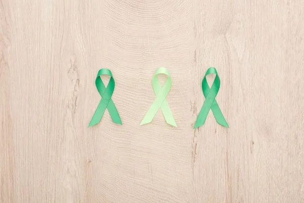 Top view of green ribbons on wooden background with copy space — Stock Photo