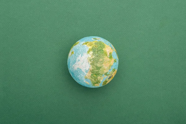 Вид сверху на игрушечную землю на красочном и зеленом фоне с копировальным пространством — стоковое фото