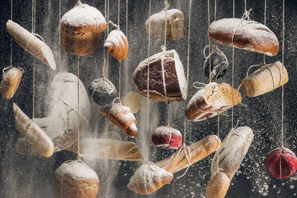 Farine blanche tombant aux pains de pain blanc et brun et pâtisserie suspendue aux cordes — Photo de stock