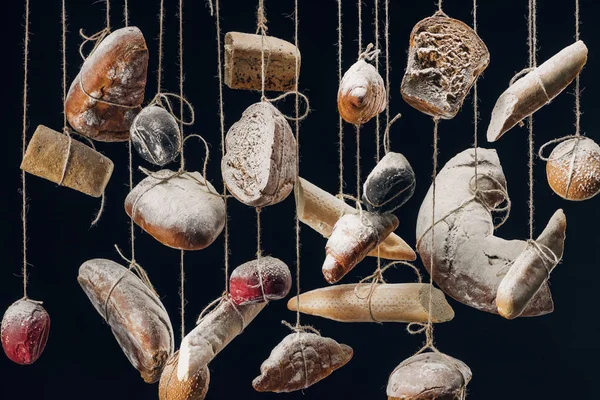 Bread with flour hanging on strings isolated on black — Stock Photo