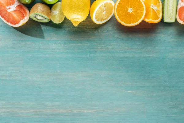 Vue de dessus des fruits juteux sur une surface texturée bleue — Photo de stock