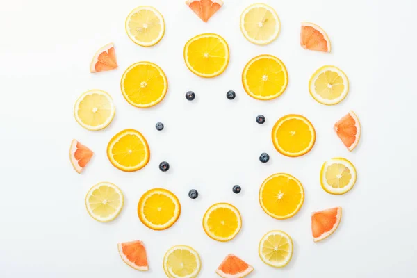 Poser à plat avec des fruits coupés et des bleuets sur la surface blanche — Photo de stock