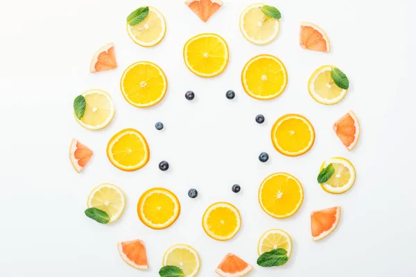 Acostado plano con frutas cortadas y arándanos en la superficie blanca - foto de stock