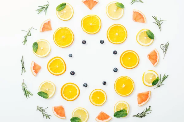 Coucher à plat avec des fruits coupés et du romarin sur une surface blanche — Photo de stock