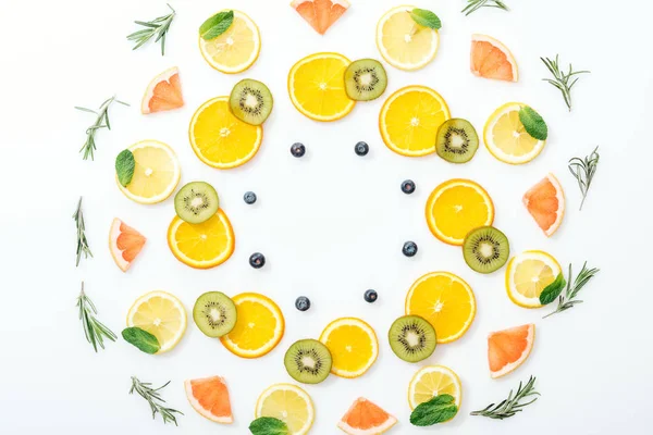 Coucher à plat avec des fruits coupés et du romarin sur une surface blanche — Photo de stock