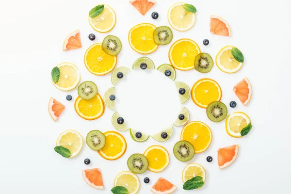 Colocação plana com frutas cortadas e mirtilos na superfície branca — Fotografia de Stock