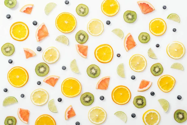 Vista dall'alto di frutta tagliata e mirtilli su superficie bianca — Foto stock