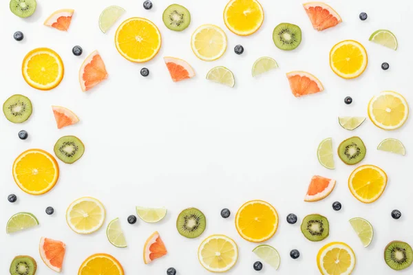 Poser à plat avec des fruits coupés et des bleuets sur la surface blanche — Photo de stock