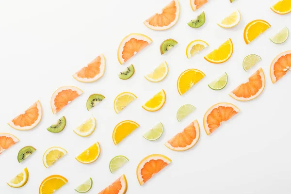 Deitado plano com suculentas frutas cortadas na superfície branca — Fotografia de Stock