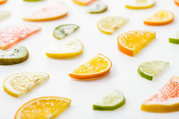 Juicy fresh sliced citrus fruits on white surface — Stock Photo