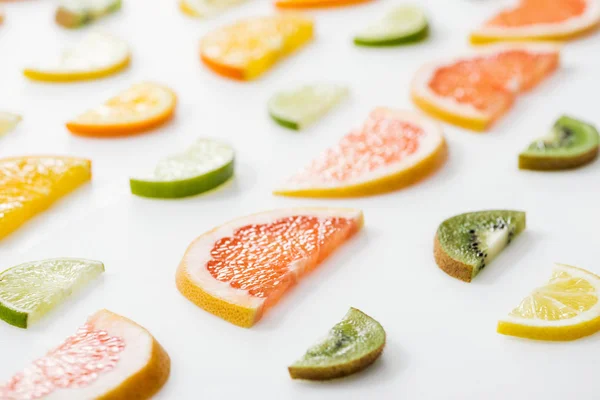 Juicy fresh sliced citrus fruits on white surface — Stock Photo
