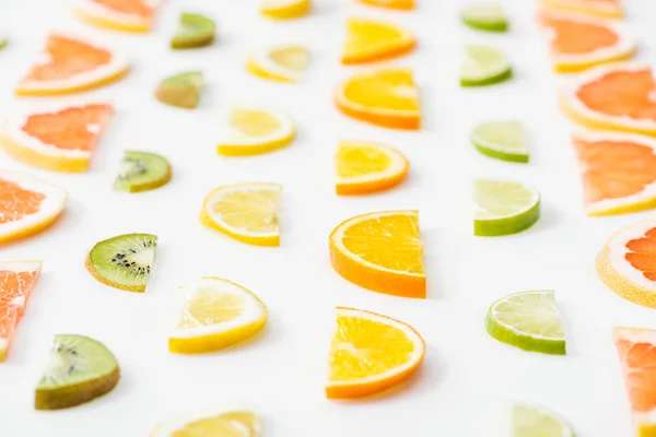 Juicy fresh sliced citrus fruits on white surface — Stock Photo