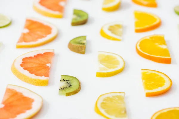 Juicy fresh sliced citrus fruits on white surface — Stock Photo