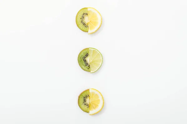 Poser à plat avec des citrons coupés, des citrons verts et des kiwis sur la surface blanche — Photo de stock