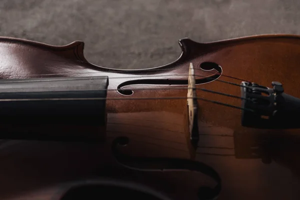 Close up de cordas no violoncelo de madeira clássica em fundo cinza texturizado — Fotografia de Stock