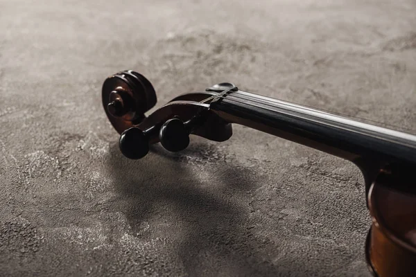 Nahaufnahme von Streichern auf klassischem Cello auf grau strukturiertem Hintergrund — Stockfoto