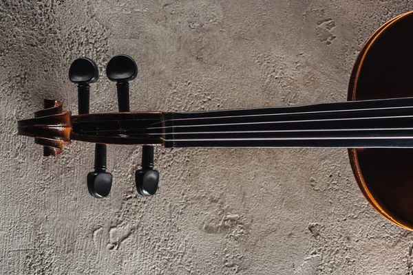 Vista superior de cuerdas de violonchelo sobre superficie texturizada gris - foto de stock