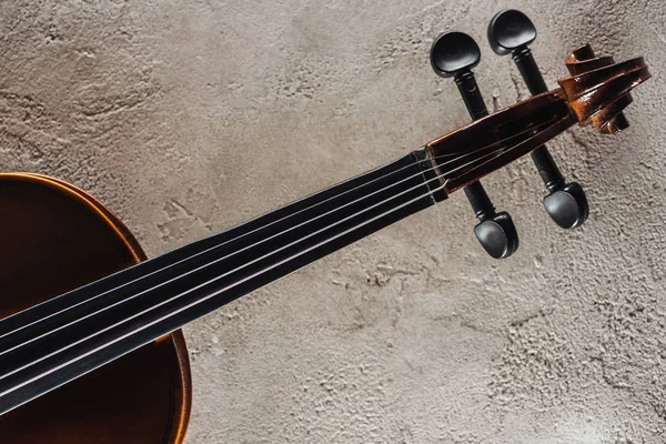 Vista superior de cordas de violoncelo na superfície texturizada cinza — Fotografia de Stock