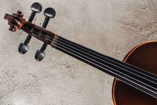 Vue de dessus des cordes sur violoncelle sur surface grise texturée — Photo de stock