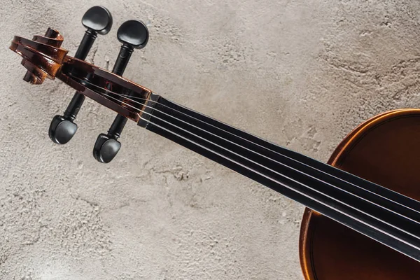 Vista superior de cordas no violoncelo na superfície texturizada cinza — Fotografia de Stock