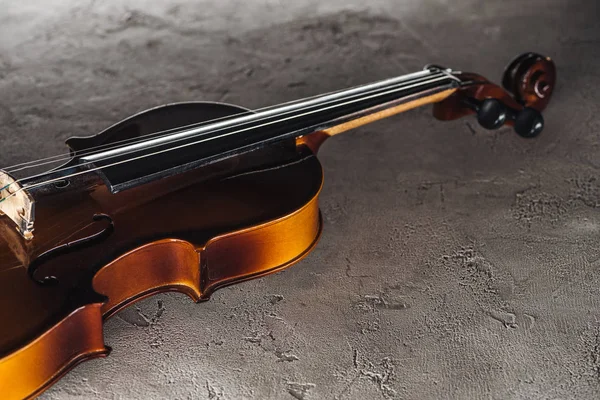 Classical violoncello in darkness on textured surface — Stock Photo