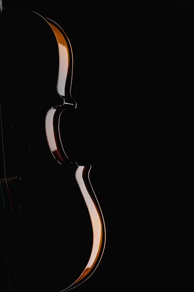 Close-up de violoncelo de madeira clássica na escuridão isolado em preto — Fotografia de Stock