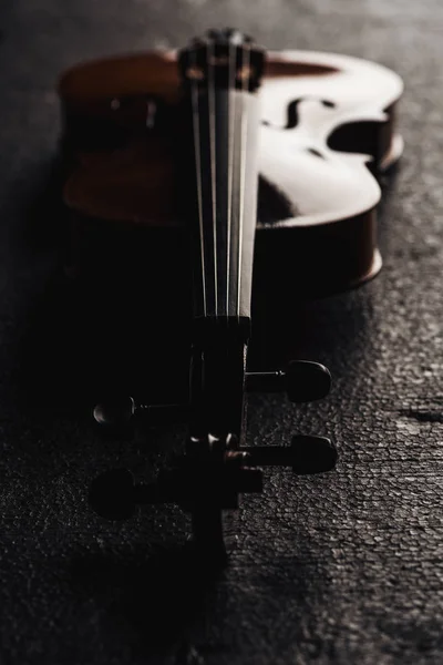 Close up of strings on cello in darkness on grey textured background — Stock Photo