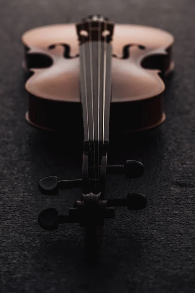 Close up of strings on cello in darkness on grey textured surface — Stock Photo