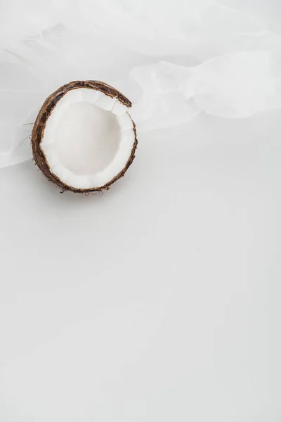 Fresh coconut half and cheesecloth on grey background — Stock Photo