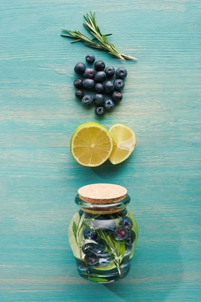 Vue du dessus de boisson de désintoxication dans un bocal avec citrons, romarin et myrtilles — Photo de stock