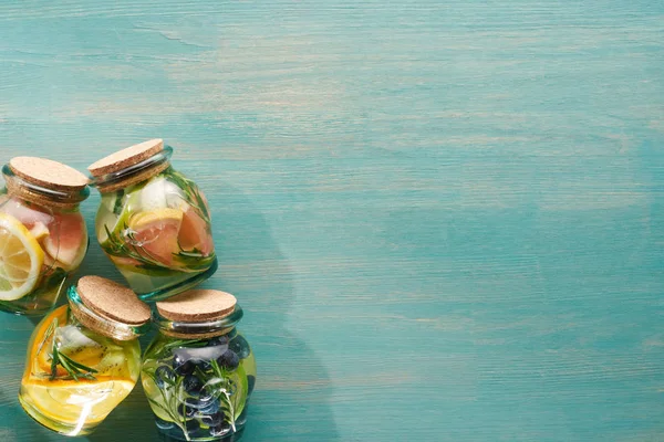 Vista superior de bebidas de desintoxicação em frascos com frutas, legumes, ervas, bagas e vegetação — Fotografia de Stock
