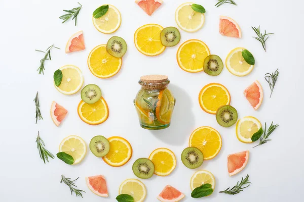 Aufgeschnittene Kiwi, Orangen, Zitronen, Grapefruits, Minze, Rosmarin und Entgiftungsgetränk im Glas auf grauem Hintergrund — Stockfoto