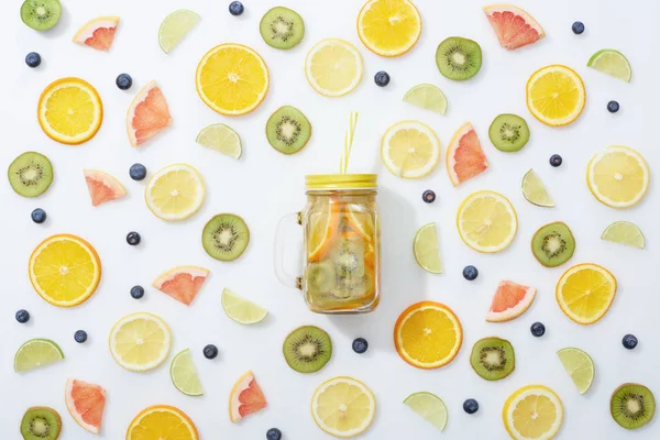 Vue du dessus de boisson de désintoxication en pot parmi les fruits et les bleuets sur fond blanc — Photo de stock