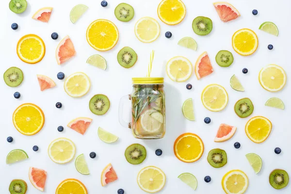 Vue du dessus de boisson de désintoxication en pot avec de la paille parmi les fruits et les bleuets sur fond blanc — Photo de stock