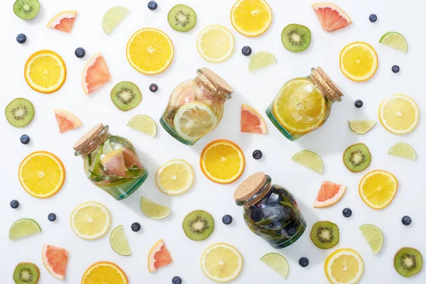 Draufsicht auf Detox-Drinks im Glas zwischen Früchten und Blaubeeren auf weißem Hintergrund — Stockfoto