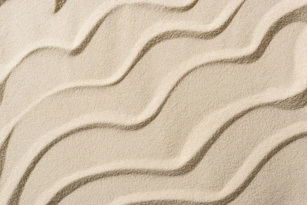 Vue de dessus du fond sablonneux beige avec des vagues lisses — Photo de stock