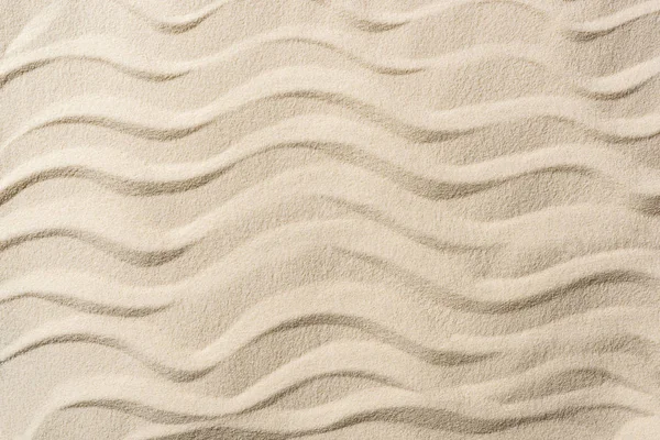 Vue de dessus du fond texturé avec sable et vagues lisses — Photo de stock