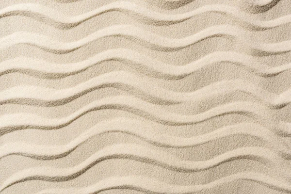 Vue de dessus du fond texturé avec sable et vagues lisses — Photo de stock